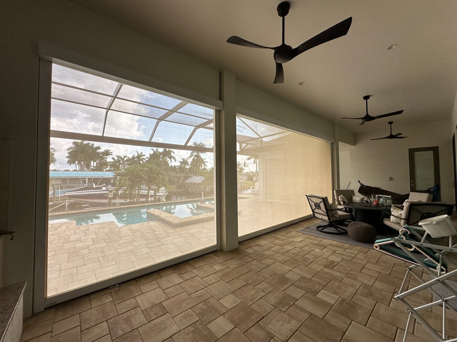 Interior view of a lanai with white-framed screens fully lowered