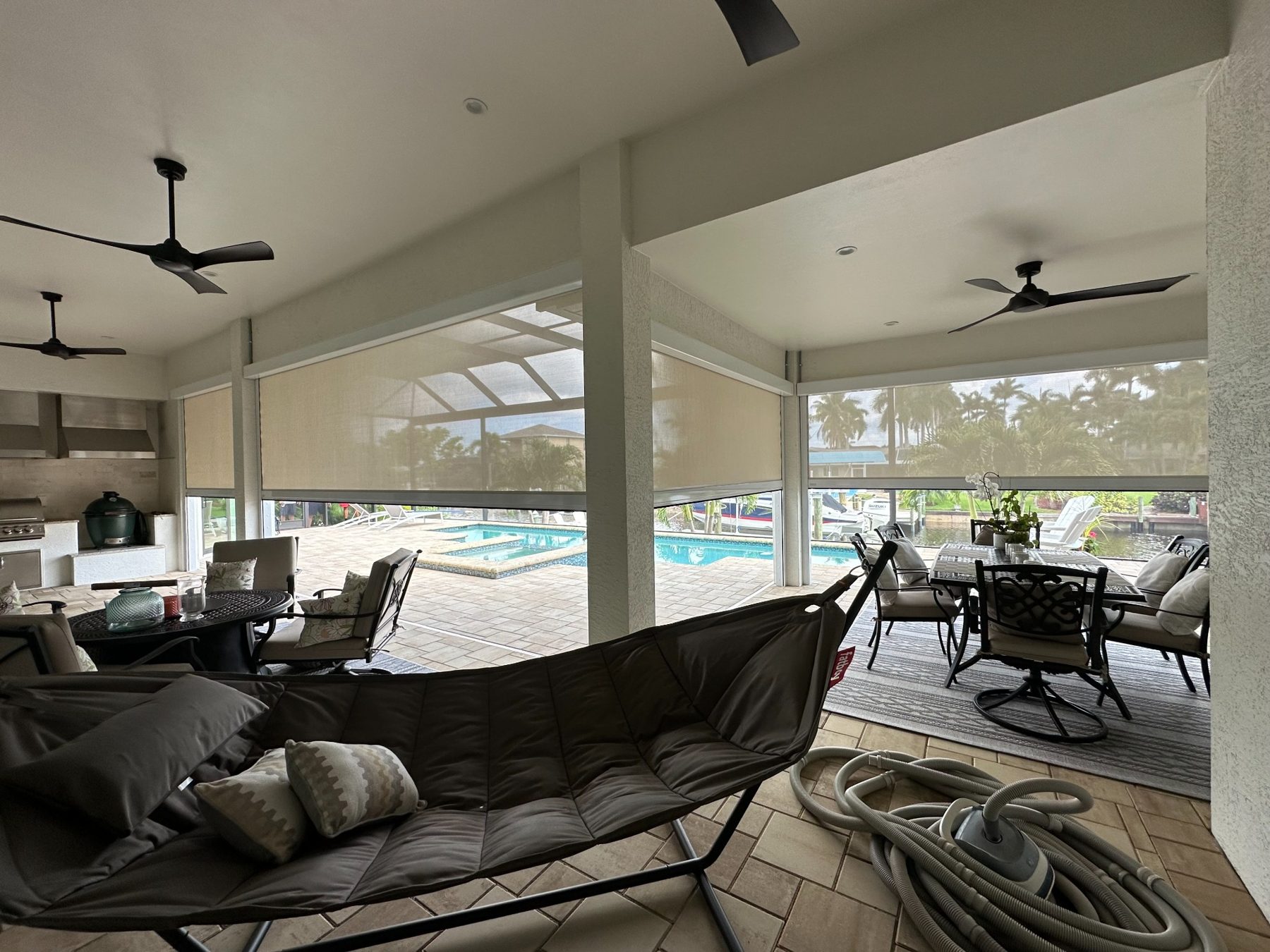 Interior view of a lanai with white-framed screens partly lowered